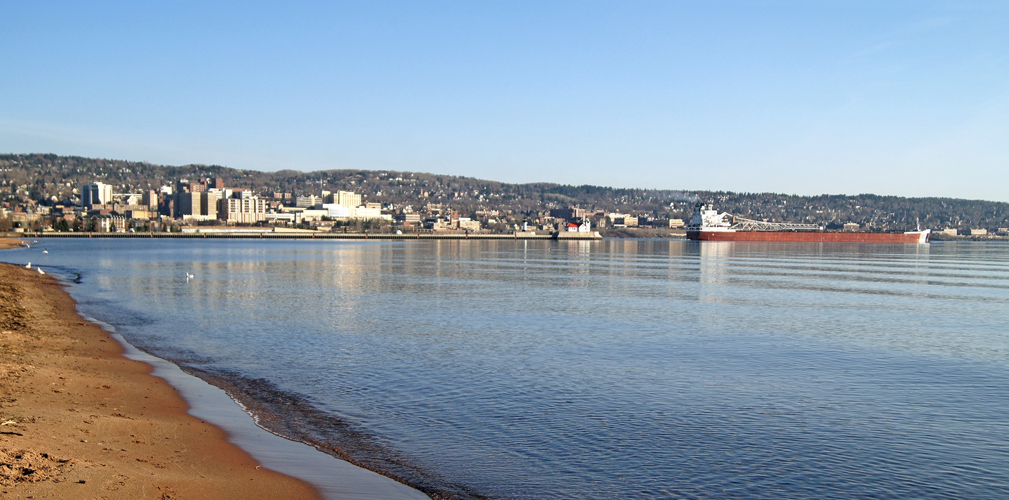 A Great Lakes freighter (called a 'Laker') leaves port with a load of taconite iron ore, on its way to the steel mills in Indiana. Duluth, sometimes called the “San Francisco of the Midwest” for its steep hills, follows the shores of Lake Superior and the St. Louis River. The city is 35 miles long and two miles wide.