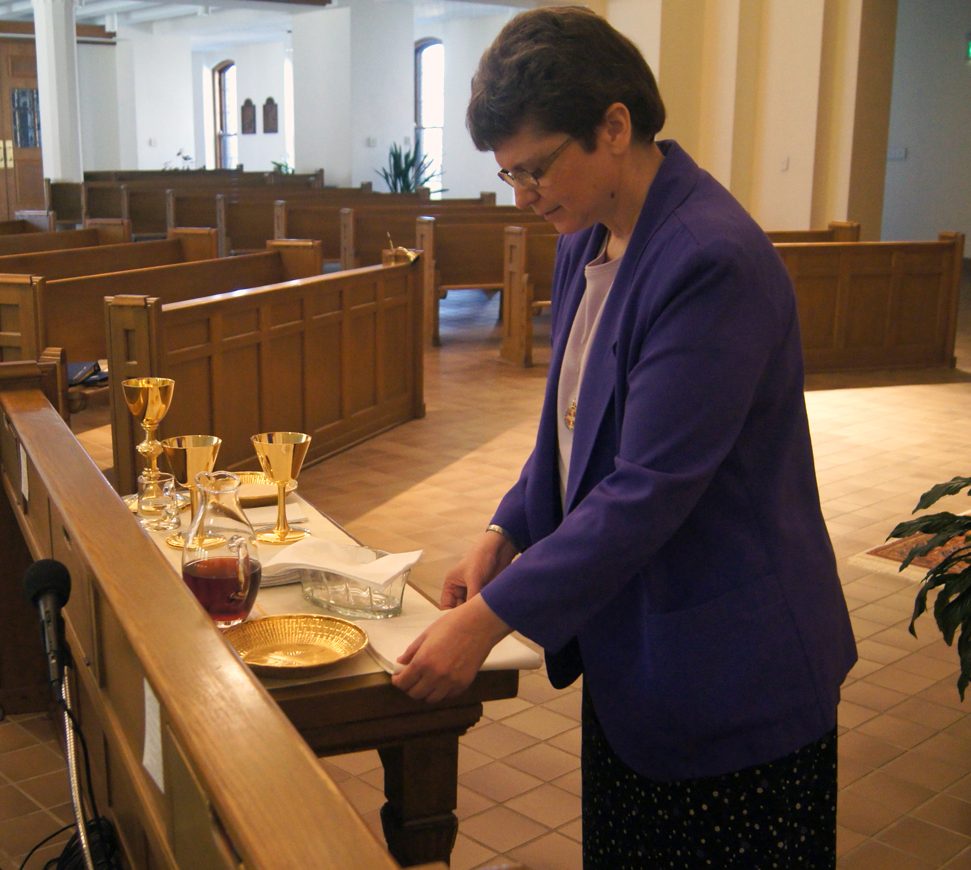 As sacristan, Sister Kathleen Del Monte lays out the credence table in preparation for Eucharist