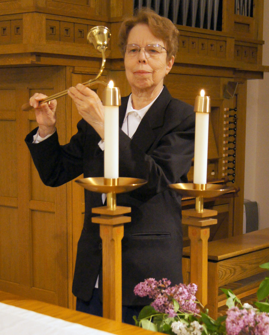 Sister Jeanne Ann Weber lights the altar candles.