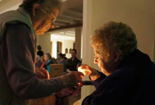 Sister Melanie and Sister Jean light a candle