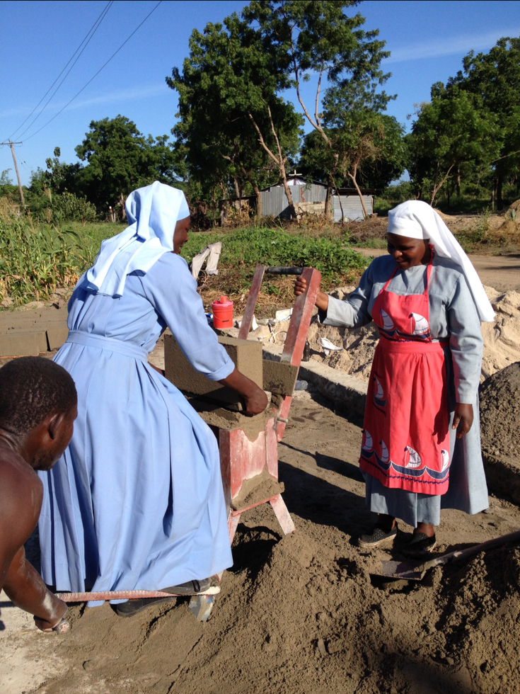 Tanzanian Sisters making blocks to build a security wall around their new school.