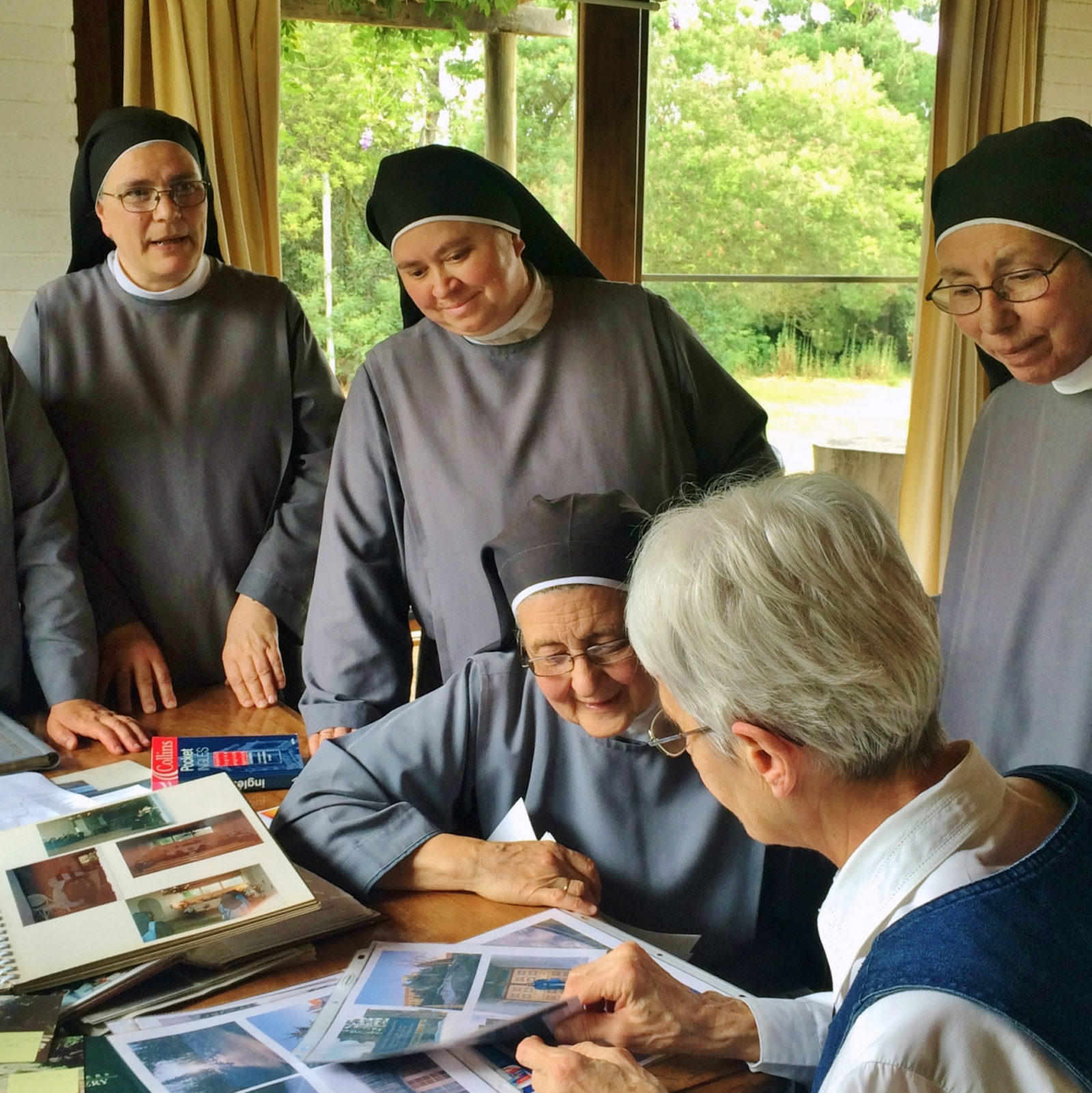 On a visit to Monasterio Santa Maria de Rautén, Sister Theresa Spinler and the Chilean Sisters share photograph albums.