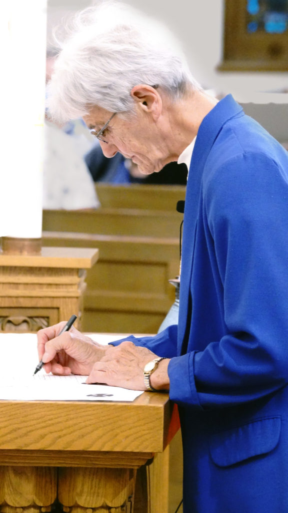 Sister Theresa Spinler signs her vow renewal at 60th jubilee.