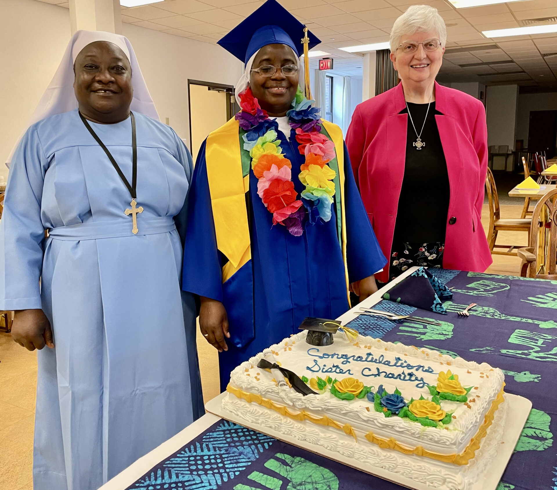 Sisters Sylvia, Charity, and Beverly with the graduation cake