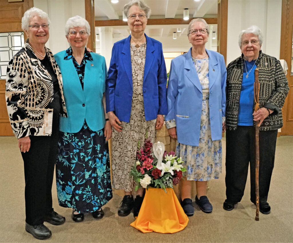 The four Jubilarians assemble with the Prioress at the baptismal font before Mass begins; from left to right Sister Sue Fortier, Prioress Beverly Raway, Sister Jeanne Ann Weber, Sister Luella Wegscheid, and Sister Renata Liegey.