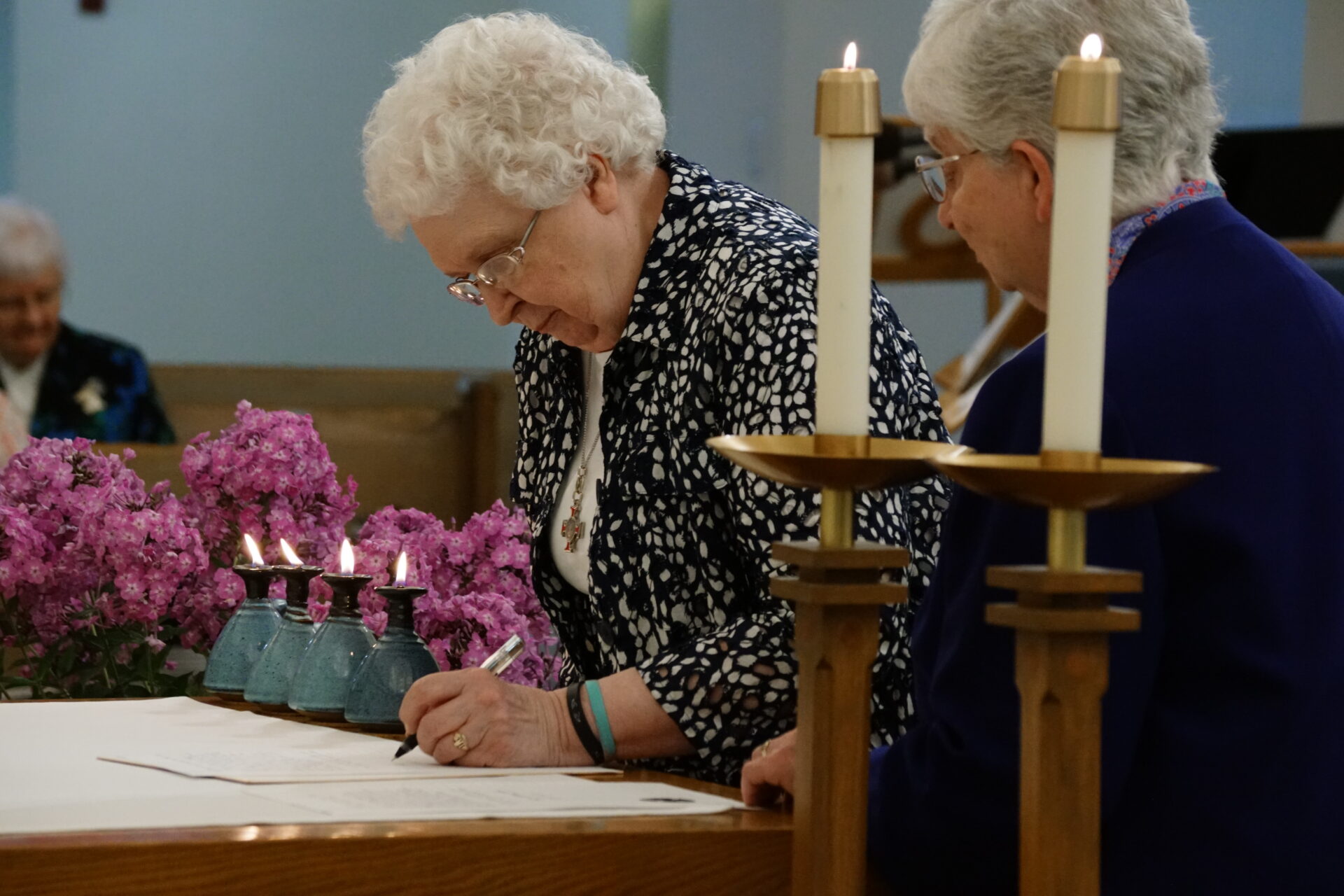 Sister Lois Ann Glaudel signs her promises, as Sister Beverly Raway witnesses and prepares to counter sign.